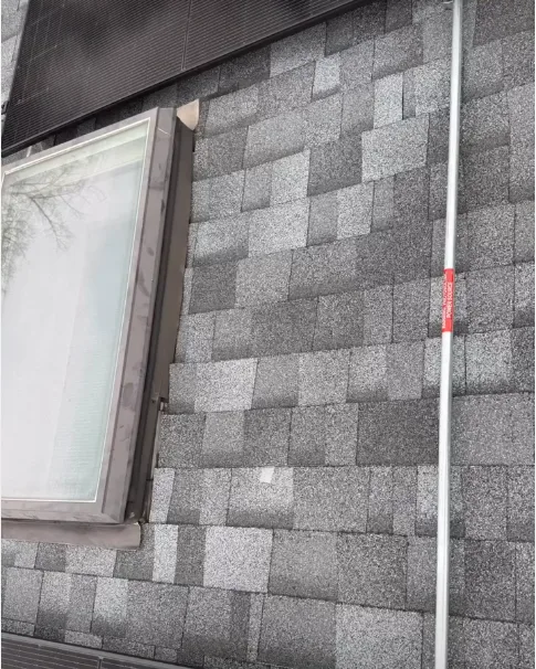 Conduit running across a roof next to a skylight